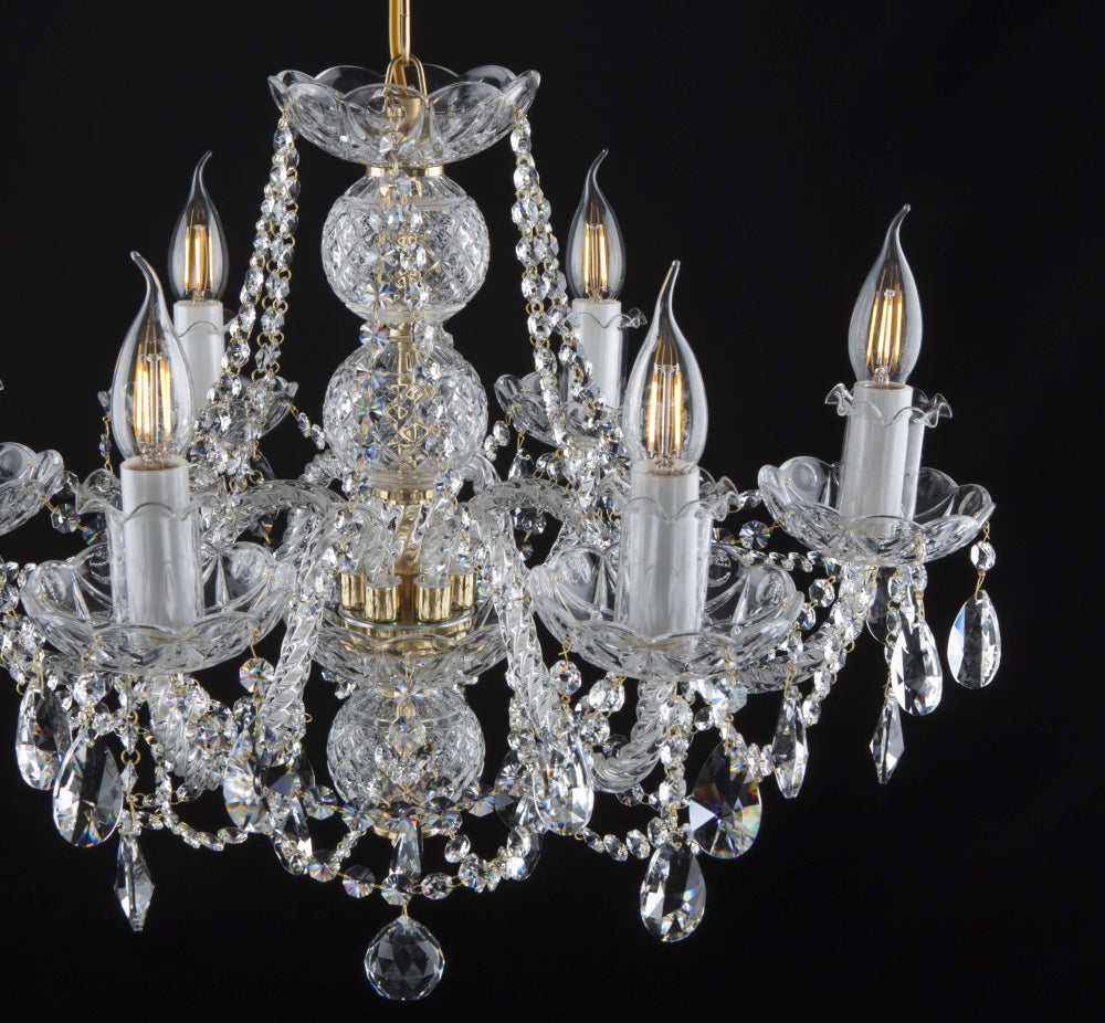 Gros plan du lustre entier, détails des bras et des pendentifs en cristal.