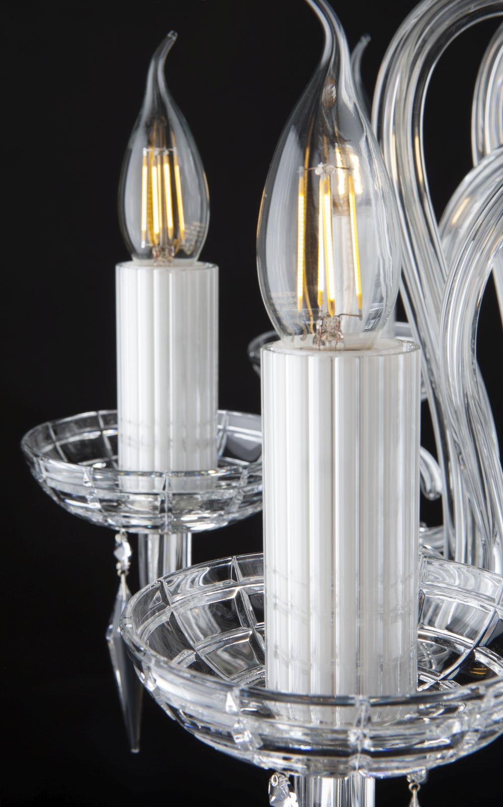 Détail des ampoules flamme dorées allumées sur leurs douilles blanches cannelées