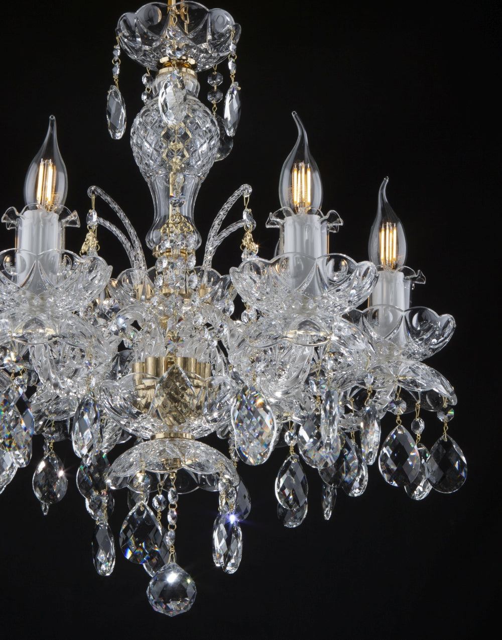Gros plan du lustre montrant les coupelles en fleur de cristal et les bougies allumées