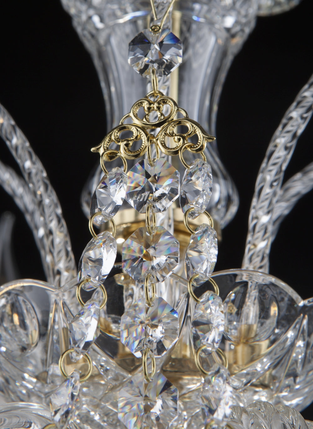 Zoom sur la colonne centrale en cristal facetté entourée de chaînettes de breloques dorées