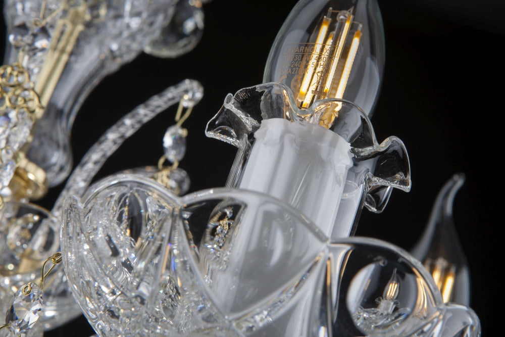 Détail d'une douille blanche avec ampoule à filament doré et coupelle festonnée en cristal