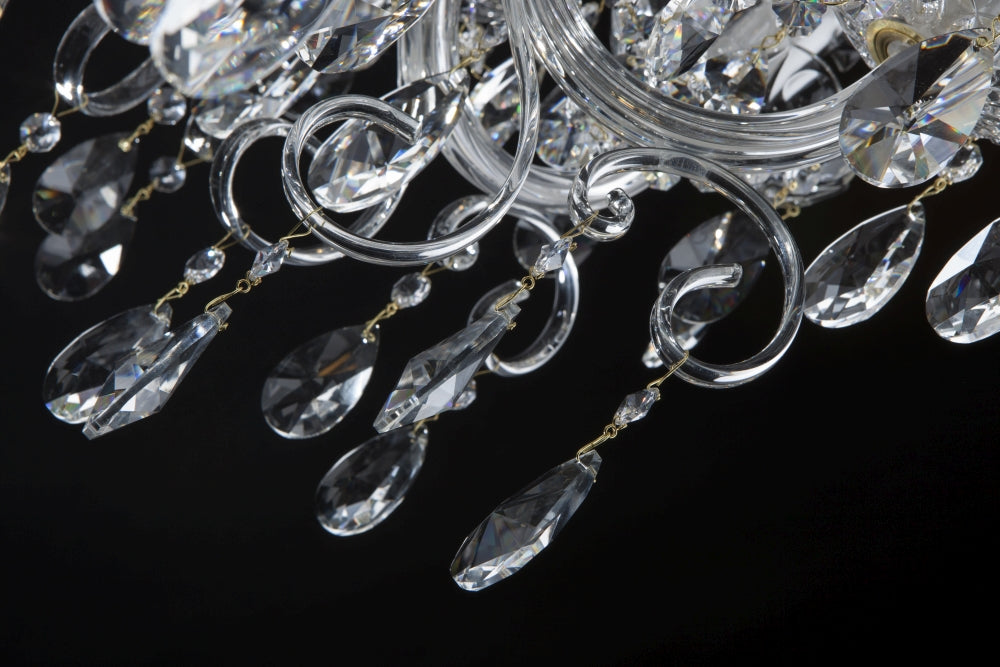 Détail des bras de verre recourbés et gouttes de cristal suspendues par fils dorés