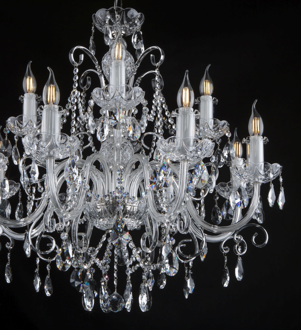 Vue rapprochée du lustre cristal, détails des pendentifs et des bras courbes.