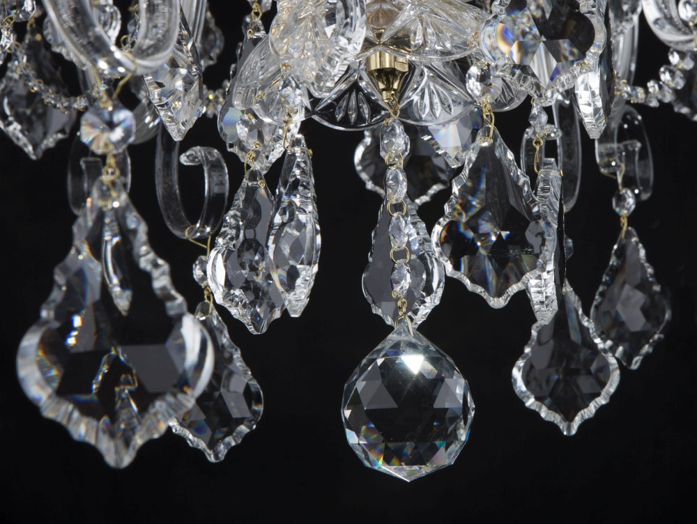 Gros plan sur les pendentifs en cristal taillé suspendus par des chaînettes dorées