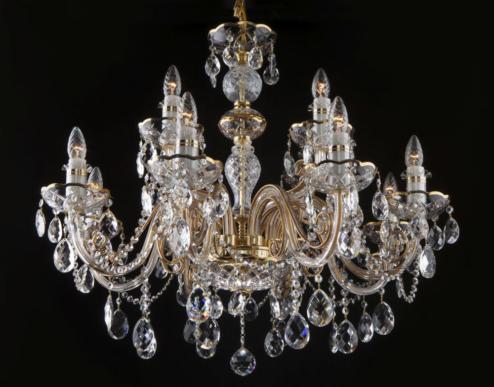 Vue rapprochée du lustre montrant les bras courbes dorés et les gouttes de cristal taillé