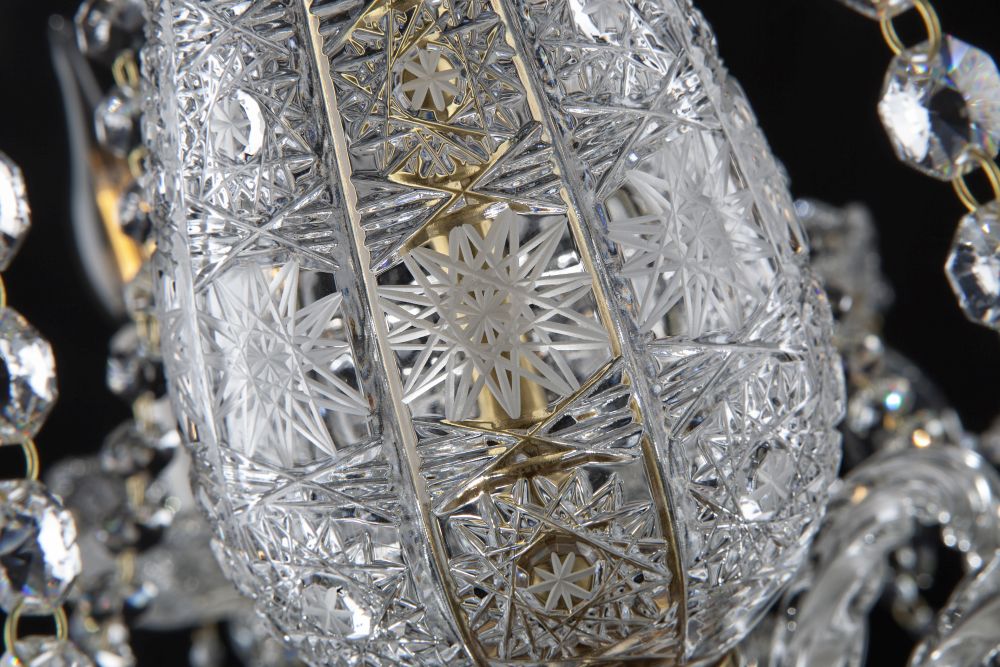 Détail du corps central en cristal taillé de motifs étoilés, cerclé de bagues dorées