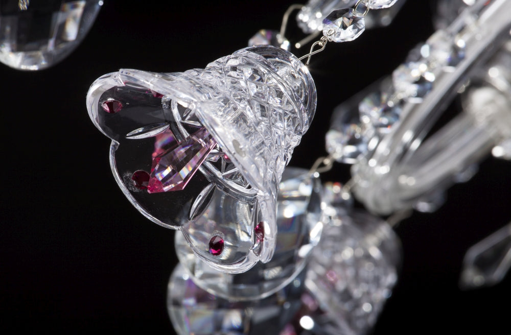 Détail d'une pendeloque en forme de cloche en cristal et ses cabochons roses