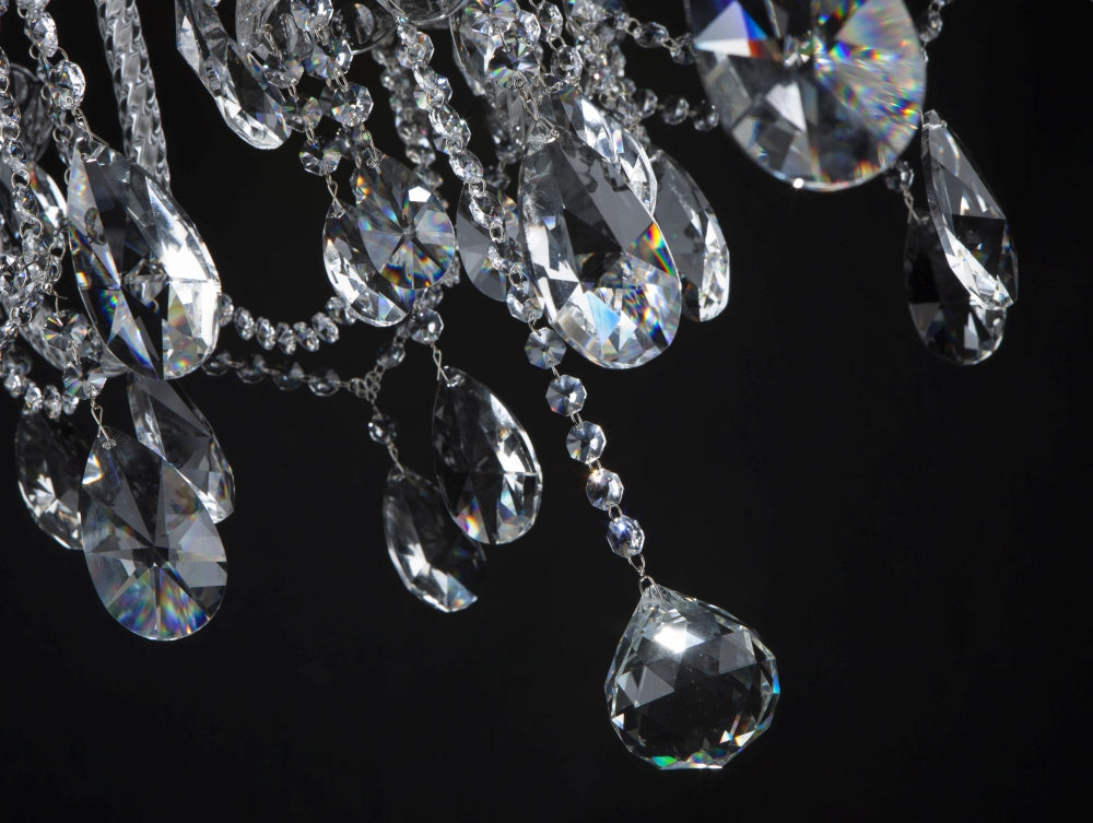 Gros plan sur les gouttes de cristal taillé suspendues aux reflets irisés