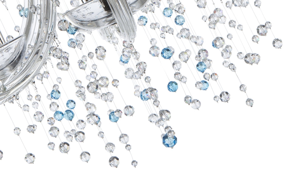 Macro des gouttes de cristal transparent et bleu suspendues sous le luminaire.