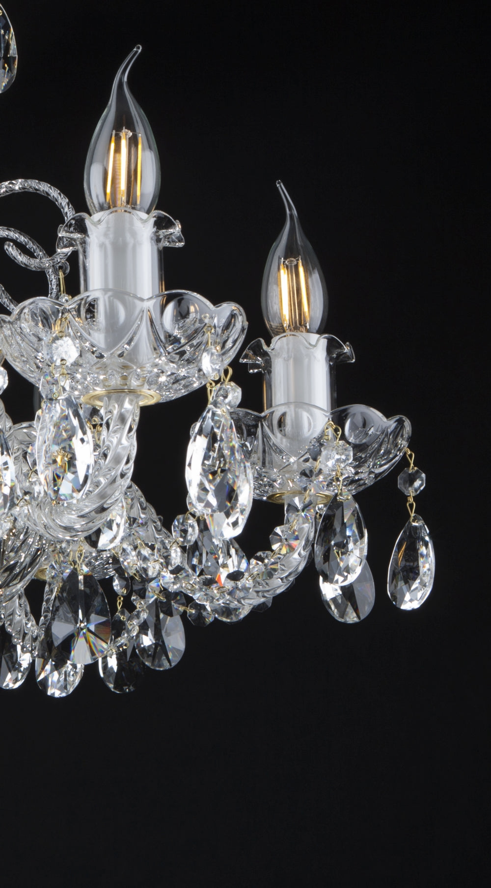 Détail des bougies et des coupelles ciselées avec pendentifs en cristal taillé.