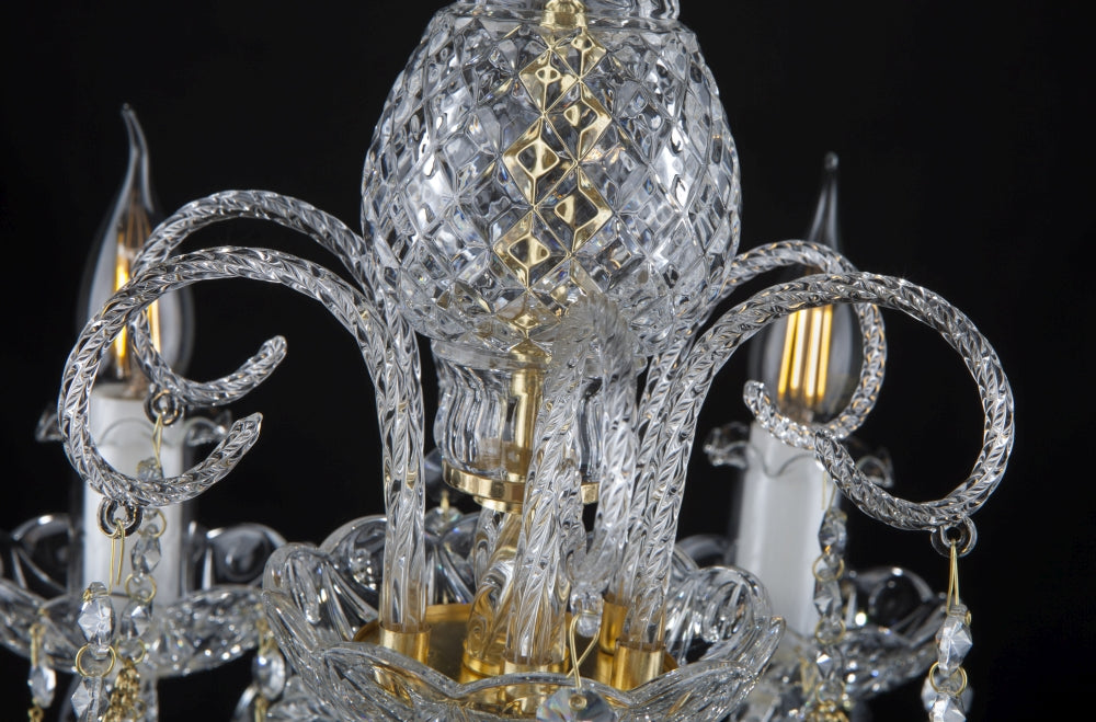 Détail du fût central en verre taillé losanges, ornements dorés et bras recourbés.