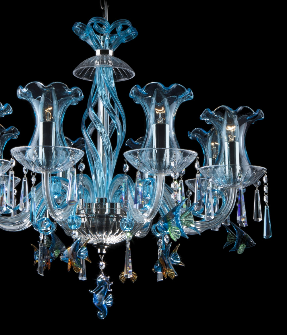 Gros plan du lustre montrant bras, fleurs de verre et pendentifs