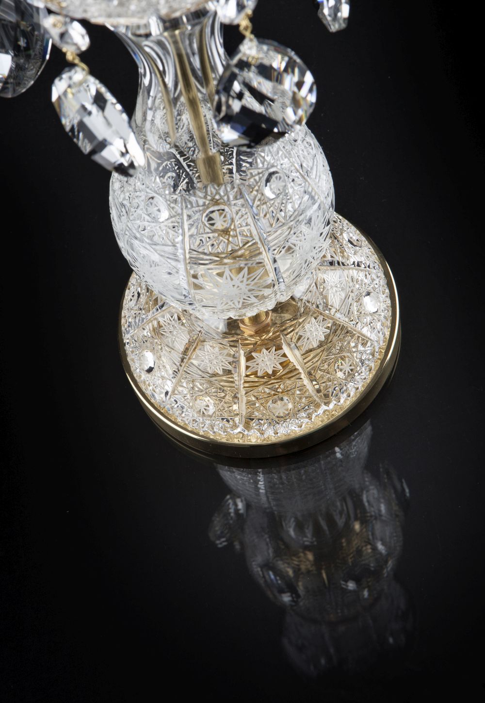 Gros plan du socle doré et de la boule de cristal taillé avec pampilles en goutte.