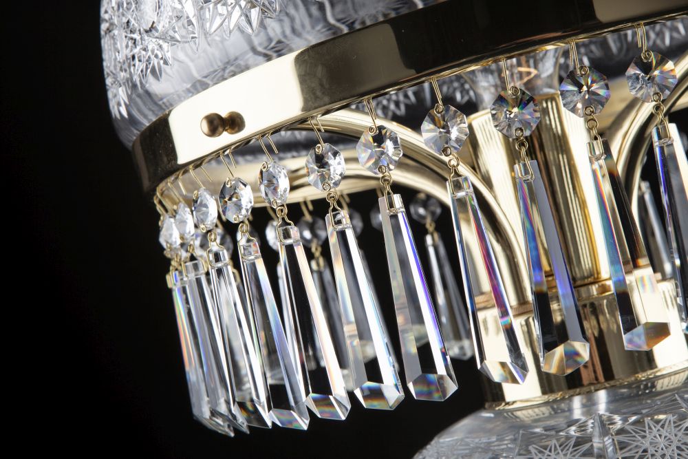 Vue rapprochée de la fixation des pendentifs sur le cercle en laiton poli.