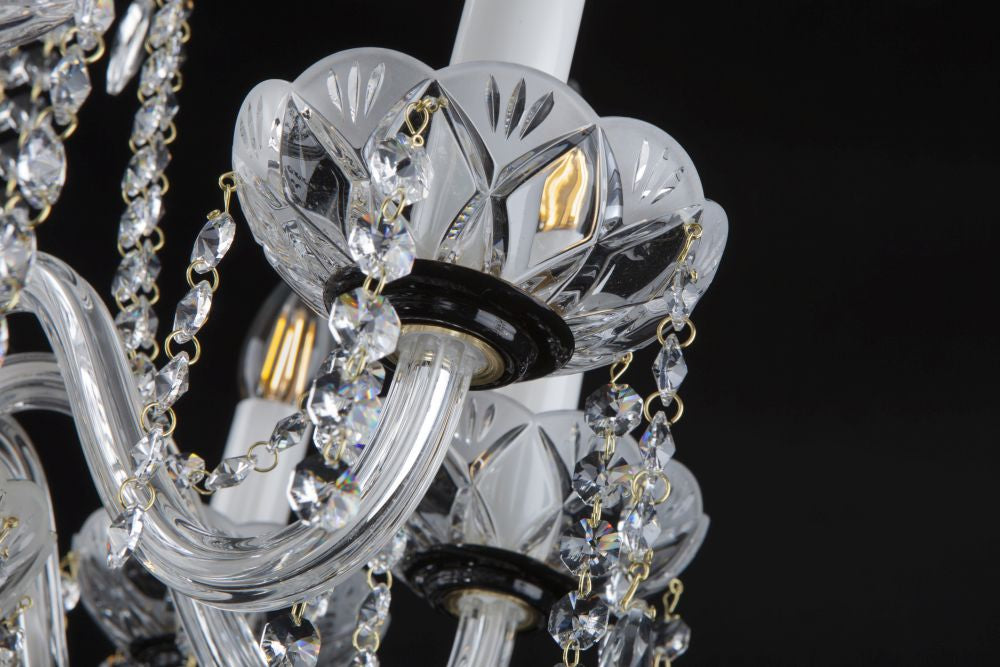 Détail d'une coupelle en cristal taillé avec chaînettes de perles et bougies blanches