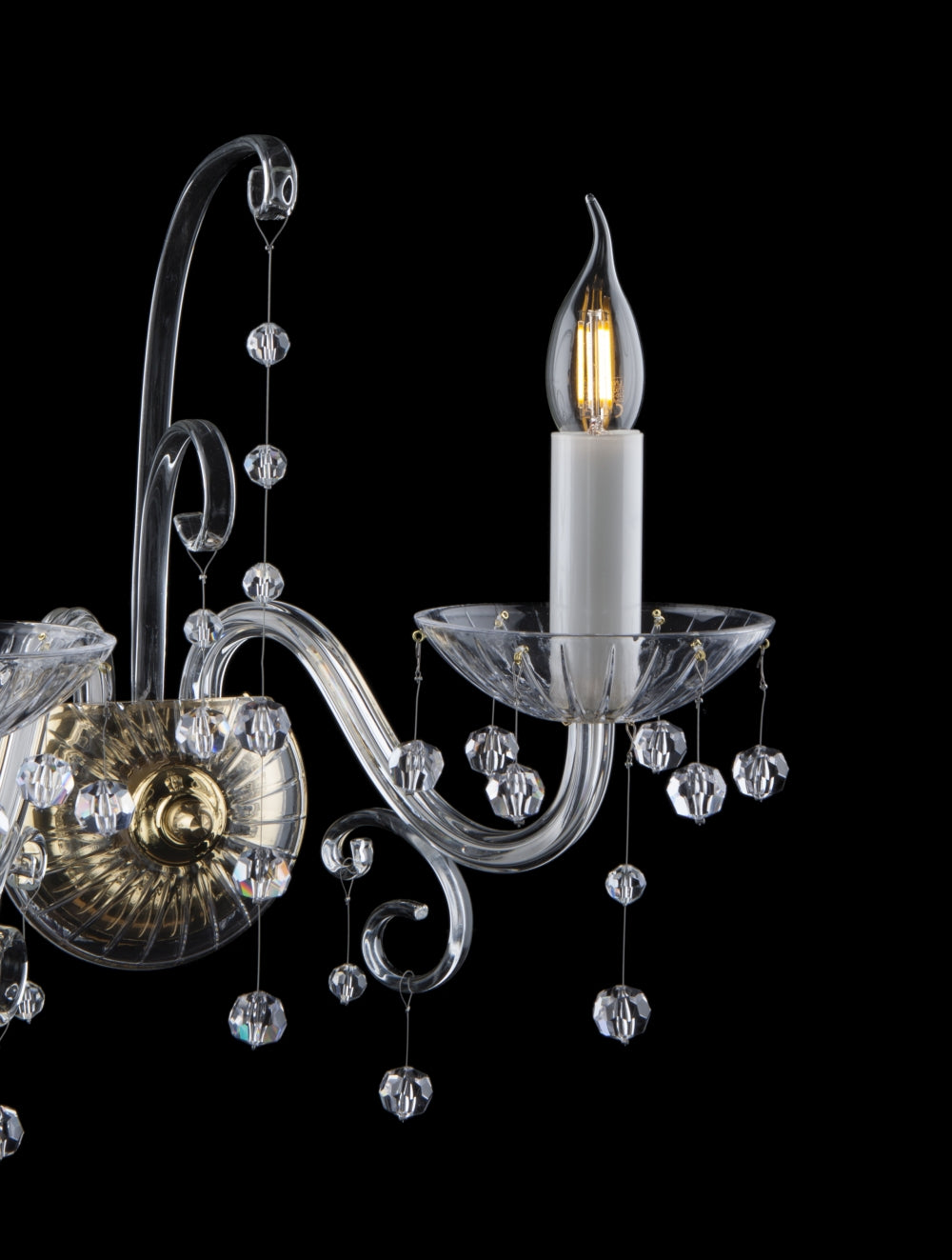 Gros plan sur un bras recourbé en verre et sa coupelle gravée avec pendentifs