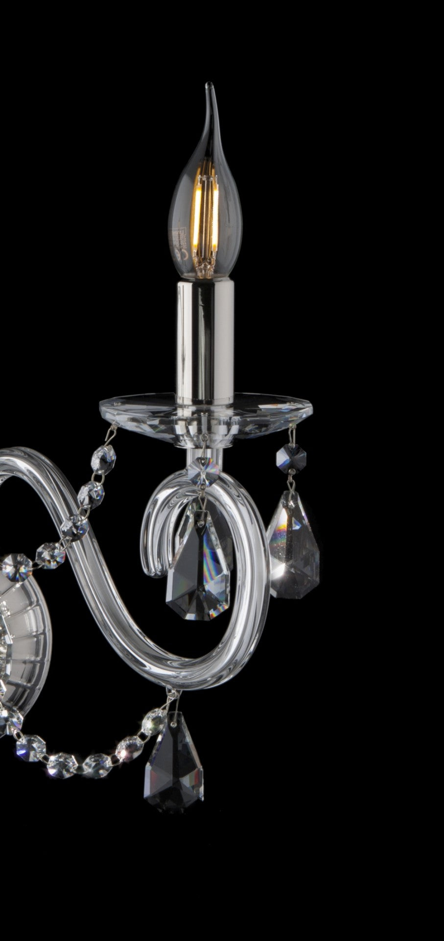 Détail d'un bras recourbé avec bougie, pampilles en cristal et ampoule allumée.