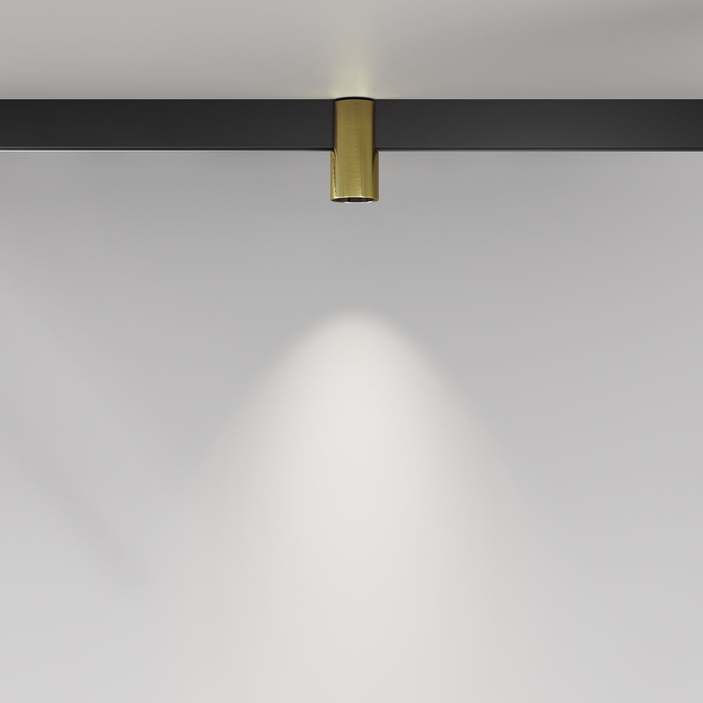 Vue en situation du spot doré projetant un faisceau lumineux sur un mur.
