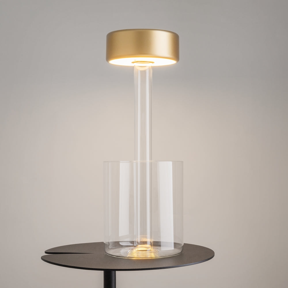Vue de trois quarts de la lampe posée sur une table noire ronde