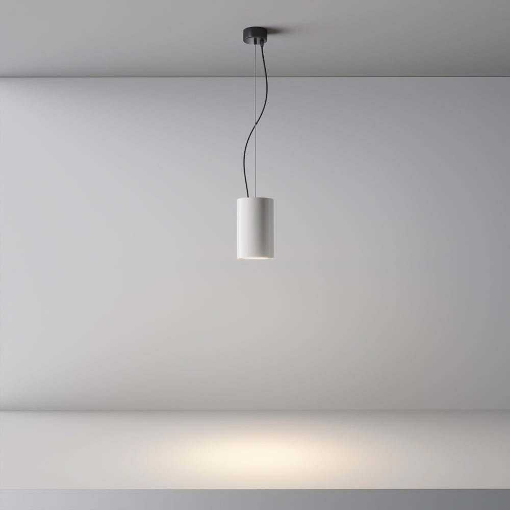 Vue d'ensemble de la suspension allumée projetant un halo lumineux au mur.