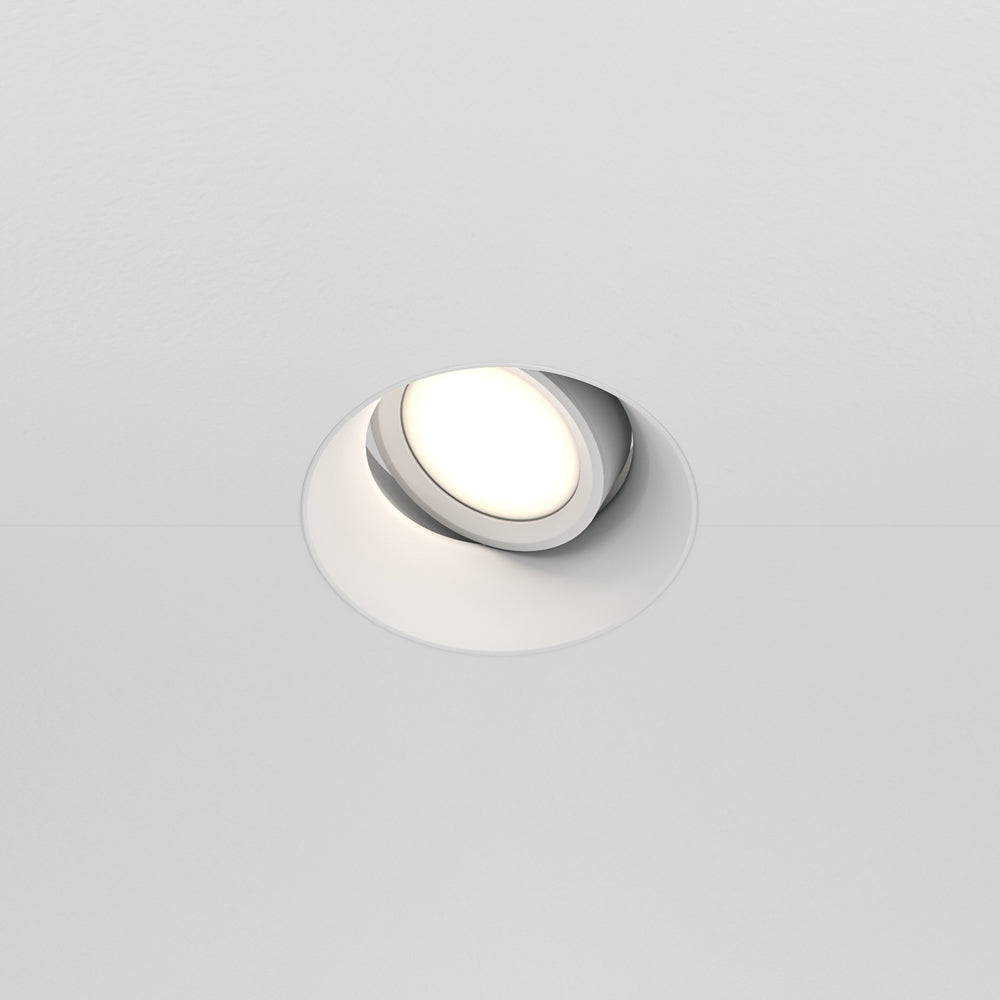 Spot encastré orientable blanc allumé, rendu discret dans un plafond clair