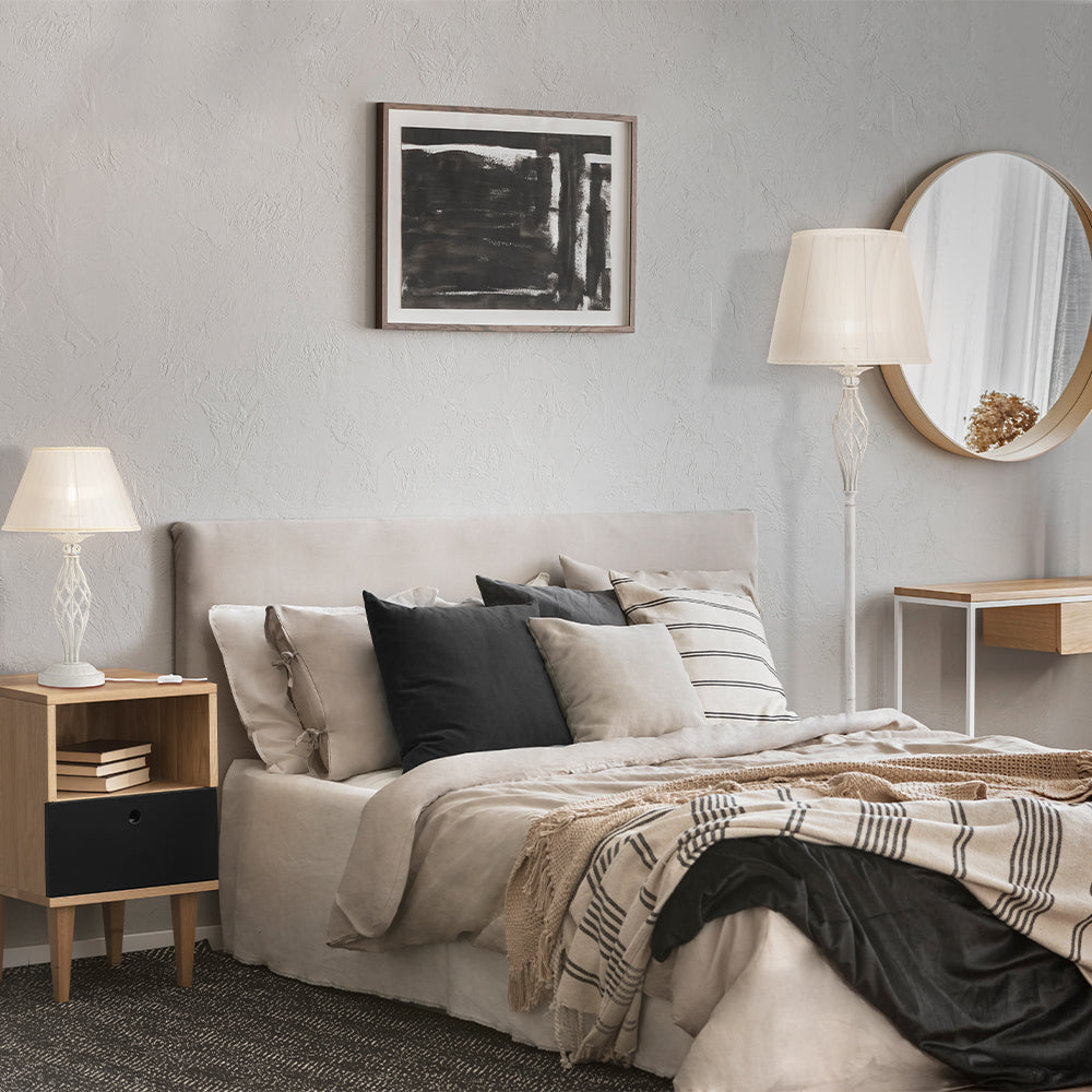 Mise en ambiance : le lampadaire blanc éclaire une chambre près du lit