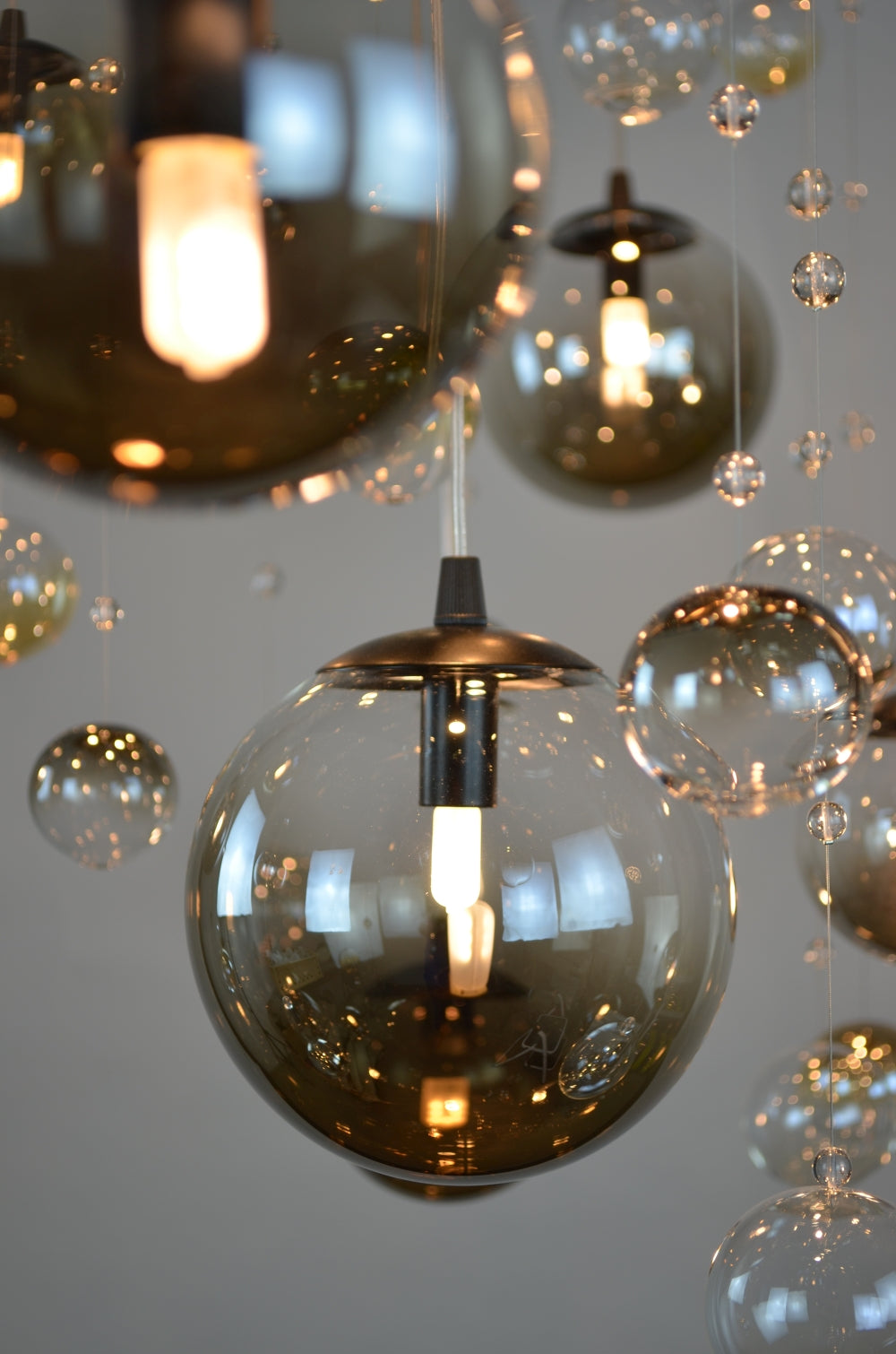 Détail rapproché d'une sphère en verre fumé avec reflets et petite perle de cristal.