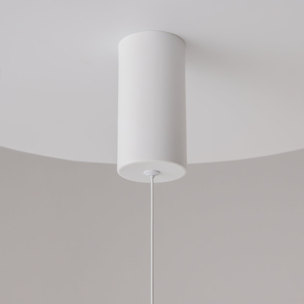 Gros plan de la rosace cylindrique blanche fixée au plafond, câble descendant