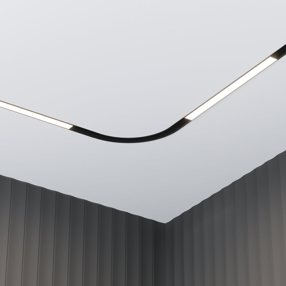Module courbe noir encastré au plafond, au-dessus de murs sombres cannelés