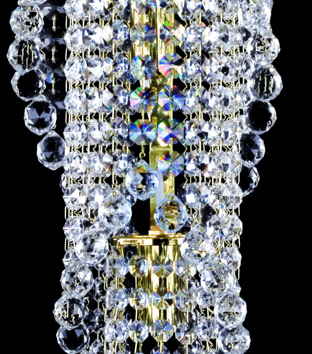Détail macro des billes de cristal facettées et tige centrale dorée réfléchissante