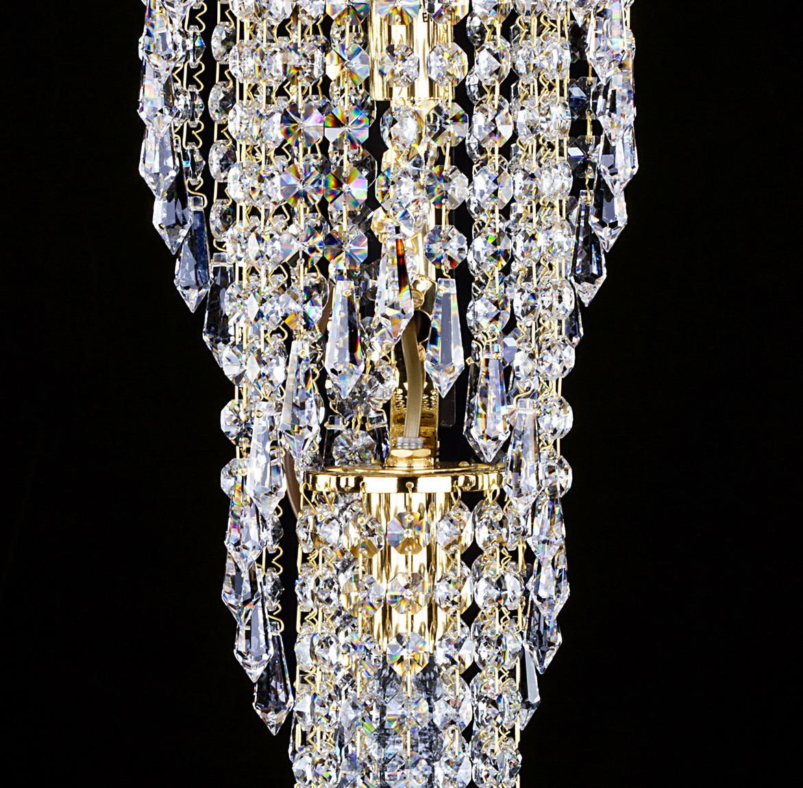 Détail rapproché du support doré et des pampilles de cristal aux reflets irisés