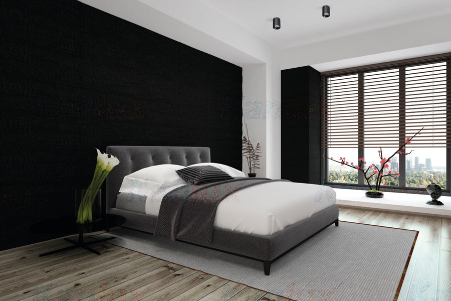 Deux spots noirs fixés au plafond éclairent une chambre moderne.