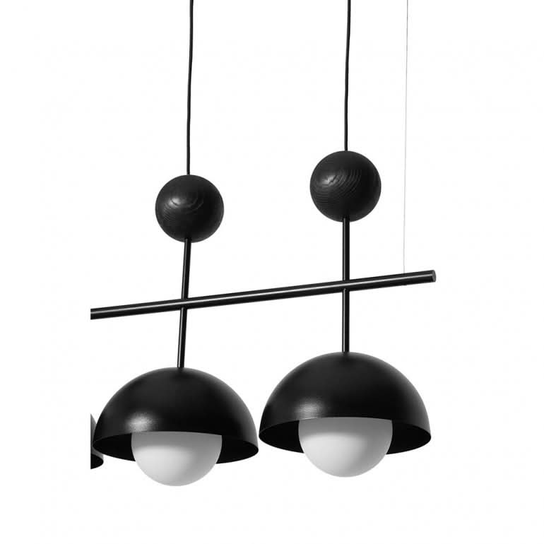 Détail rapproché de deux abat-jours noirs et des sphères décoratives sur tiges fines