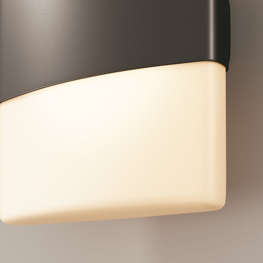 Détail rapproché du diffuseur blanc allumé sous la bande noire, lumière chaude.