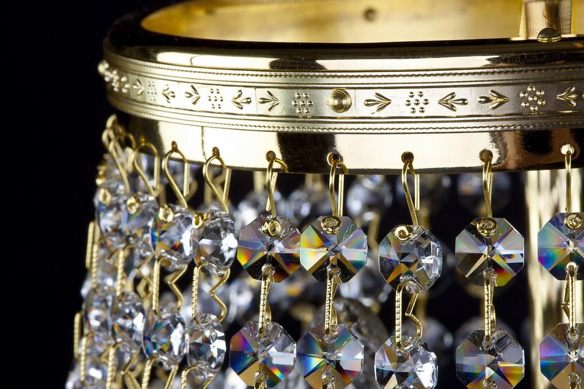 Détail de la finition dorée et de la bordure ornée, cristaux suspendus en gros plan.