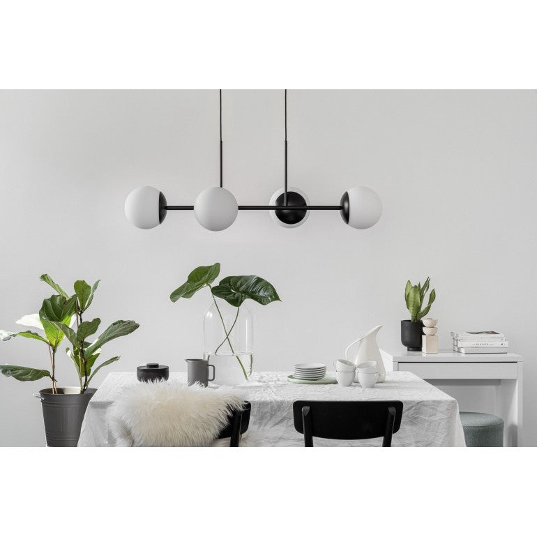 Ambiance salle à manger avec la version noire et blanches, plantes vertes et vaisselle