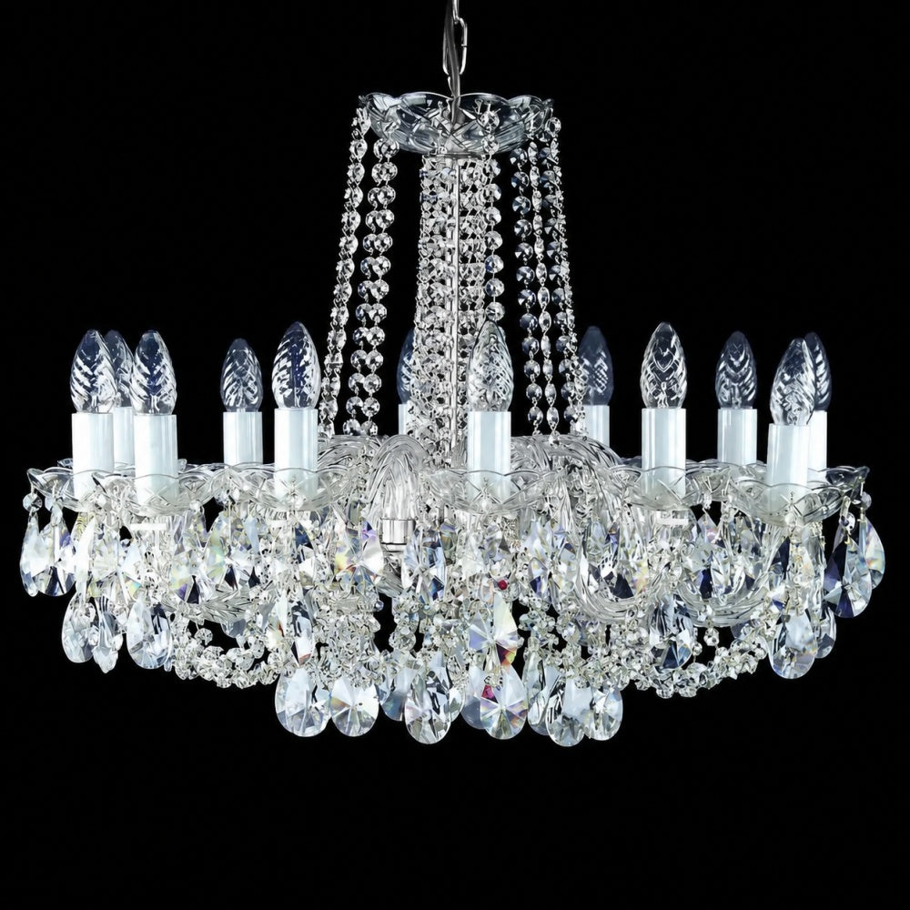 Vue de face du lustre éteint, cristaux et chaînes transparentes sur fond sombre.