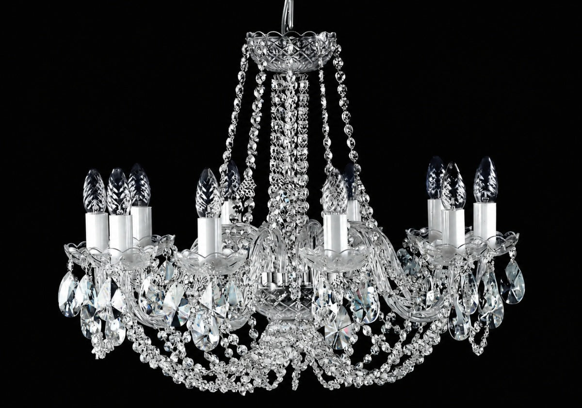Même lustre éteint, cristaux clairs et douilles blanches sur fond noir.