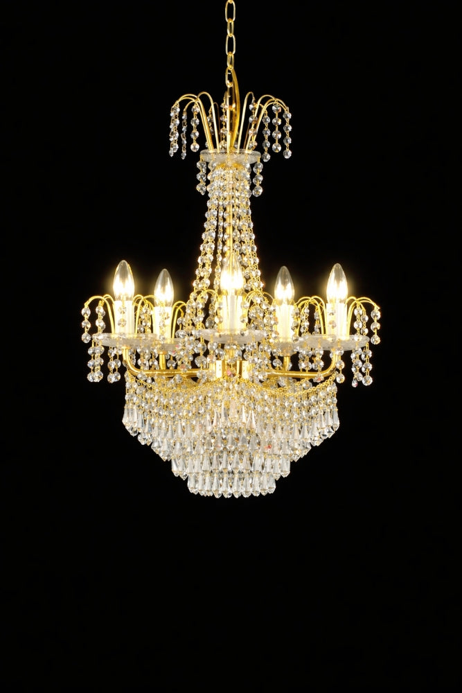Lustre doré allumé, cinq ampoules flamme éclairées, pampilles scintillantes