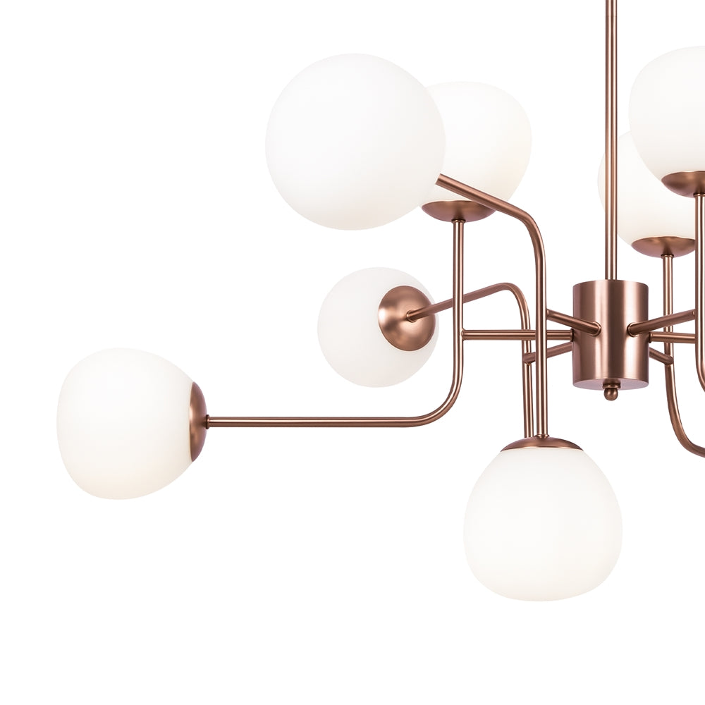 Détail des bras coudés en métal cuivré et des diffuseurs sphériques en verre opalin