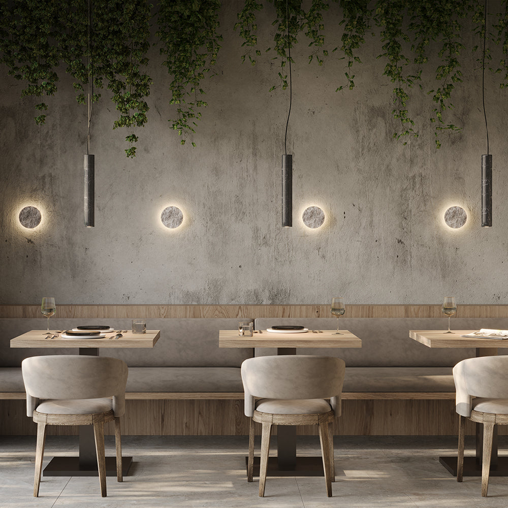 Mise en ambiance dans un restaurant avec suspensions cylindriques et appliques murales.