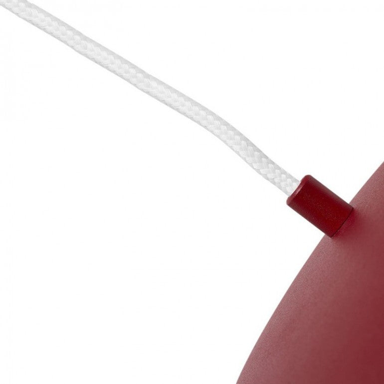 Détail du passe-câble cylindrique rouge et de la tresse textile blanche.