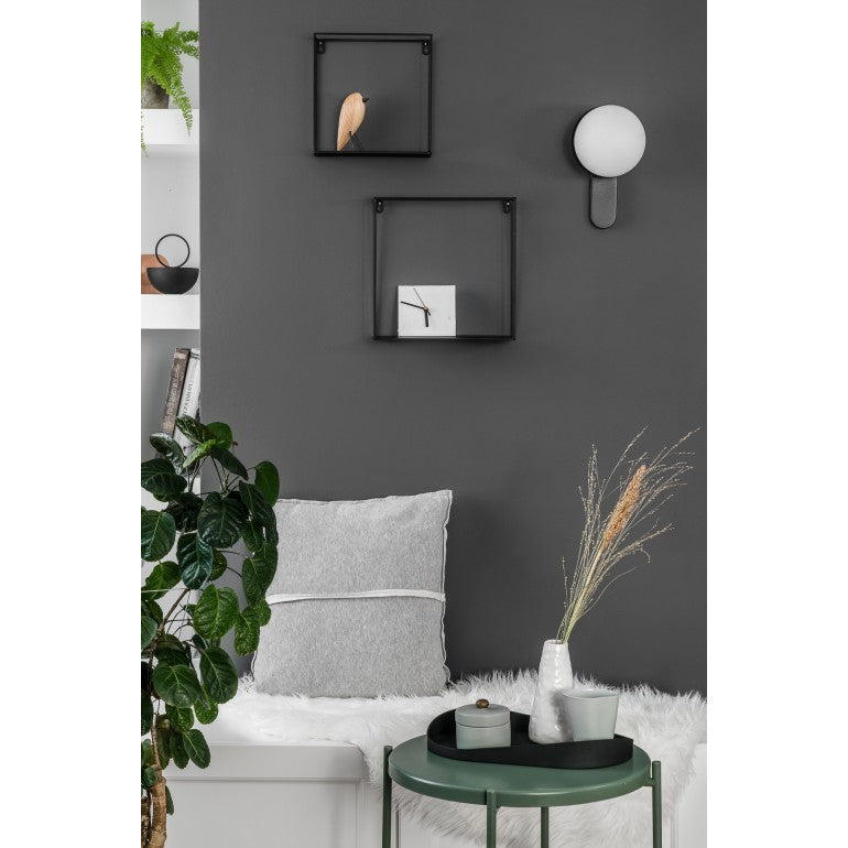 Mise en ambiance sur mur gris anthracite avec applique blanche allumée au-dessus d'un banc.