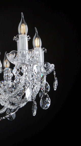 Détail latéral des bras lumineux, avec bobèches et pendentifs en cristal taillé.