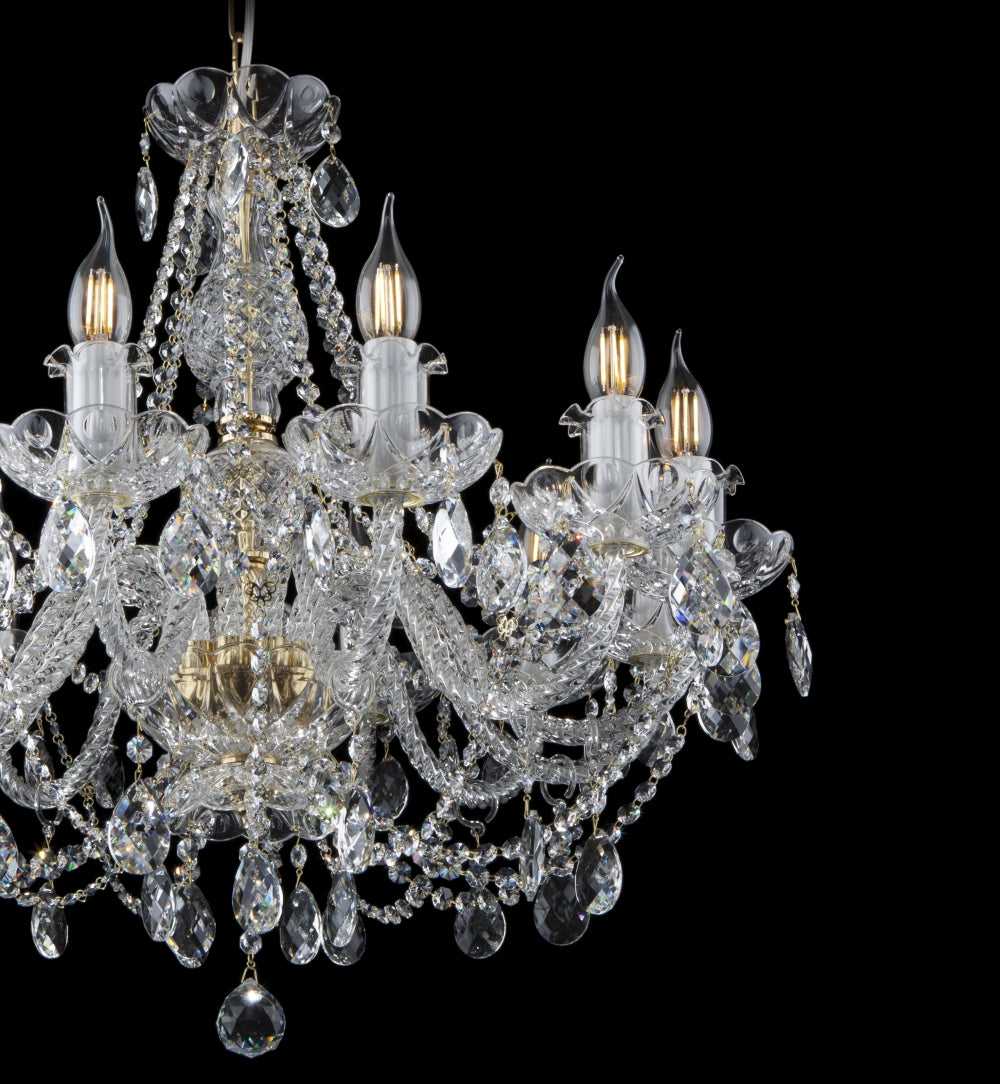 Gros plan sur le centre du lustre, bras torsadés et gouttes de cristal taillé