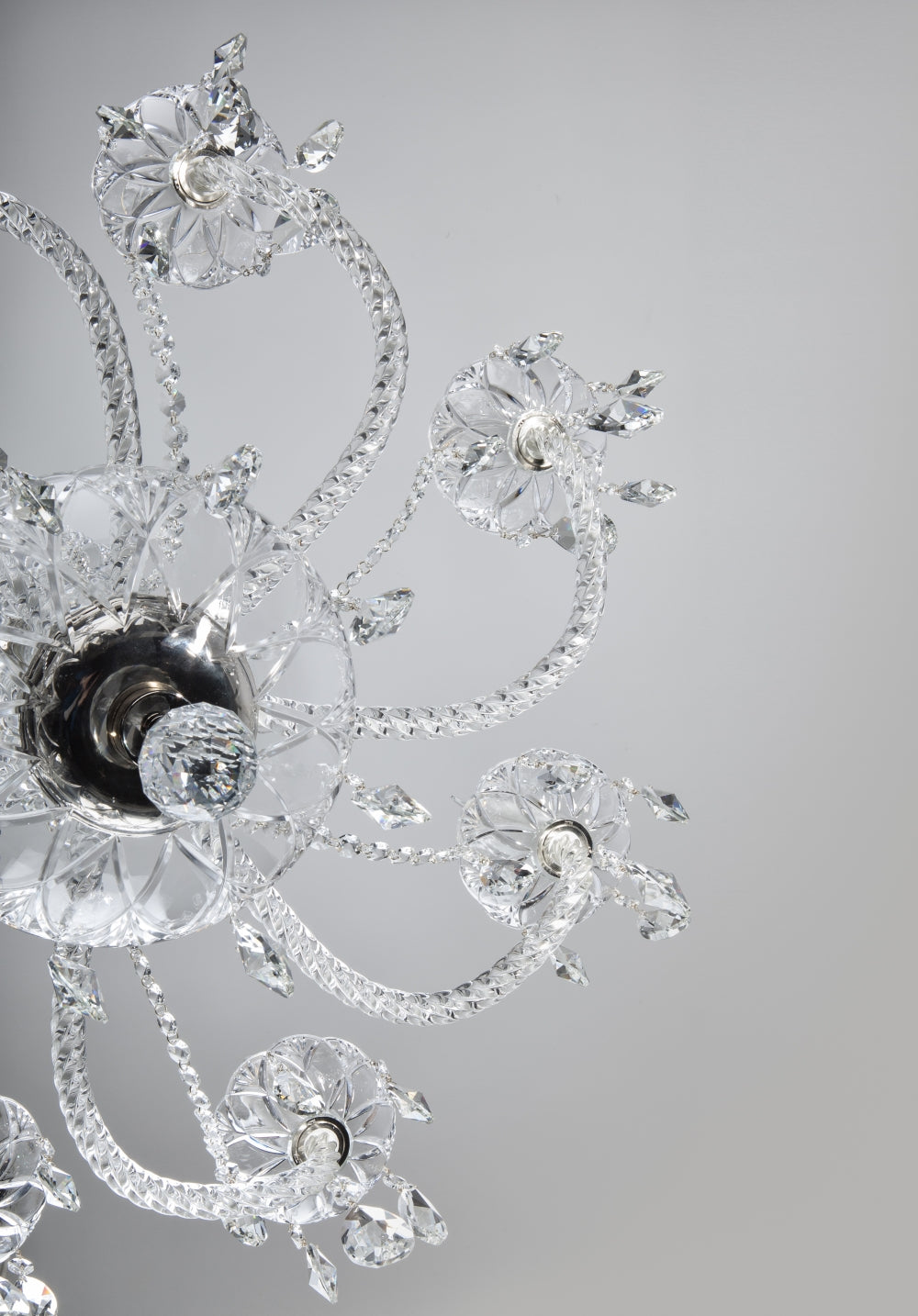 Détail vu de dessous des bras torsadés, coupelles en fleur et pendants de cristal