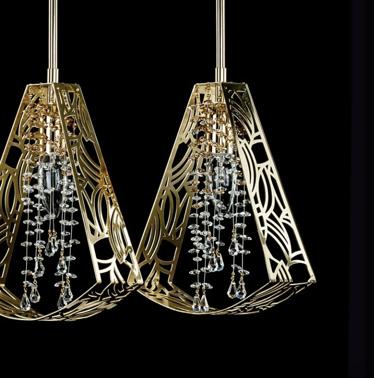 Détail rapproché doré des deux abat-jours ajourés avec pendants cristal en gouttes