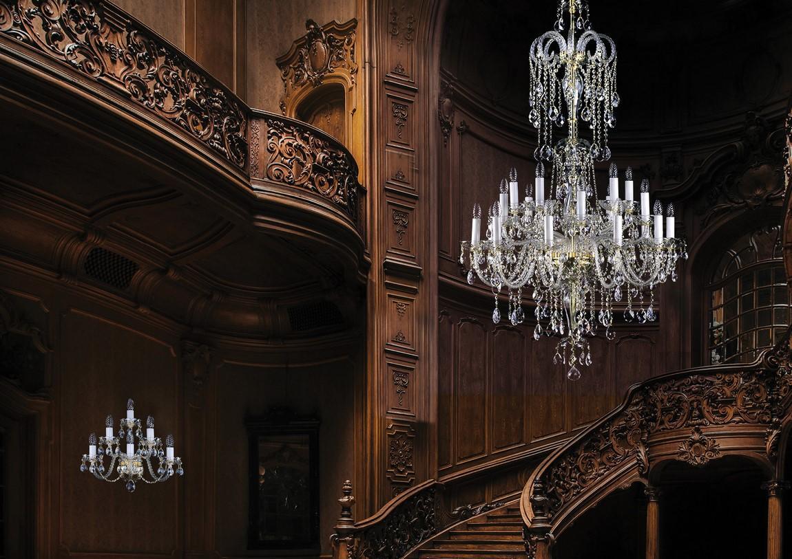 Mise en ambiance du lustre suspendu dans une grande cage d'escalier en bois sculpté