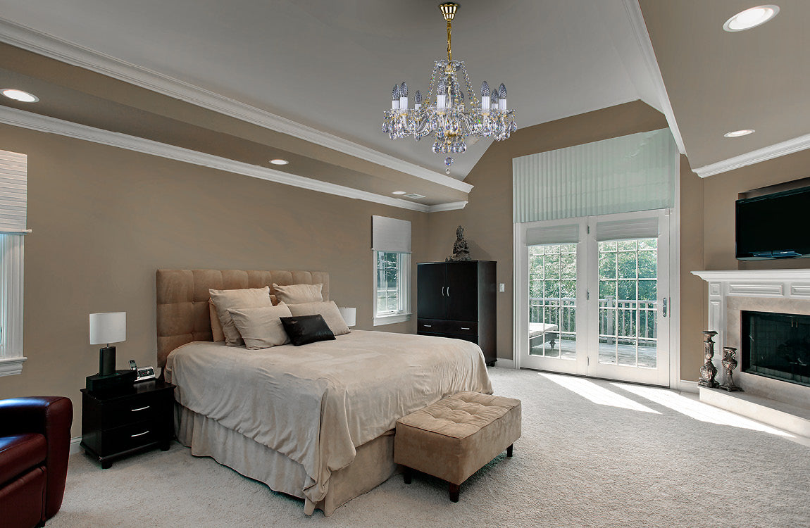 Lustre suspendu dans une chambre beige avec lit et grandes fenêtres.