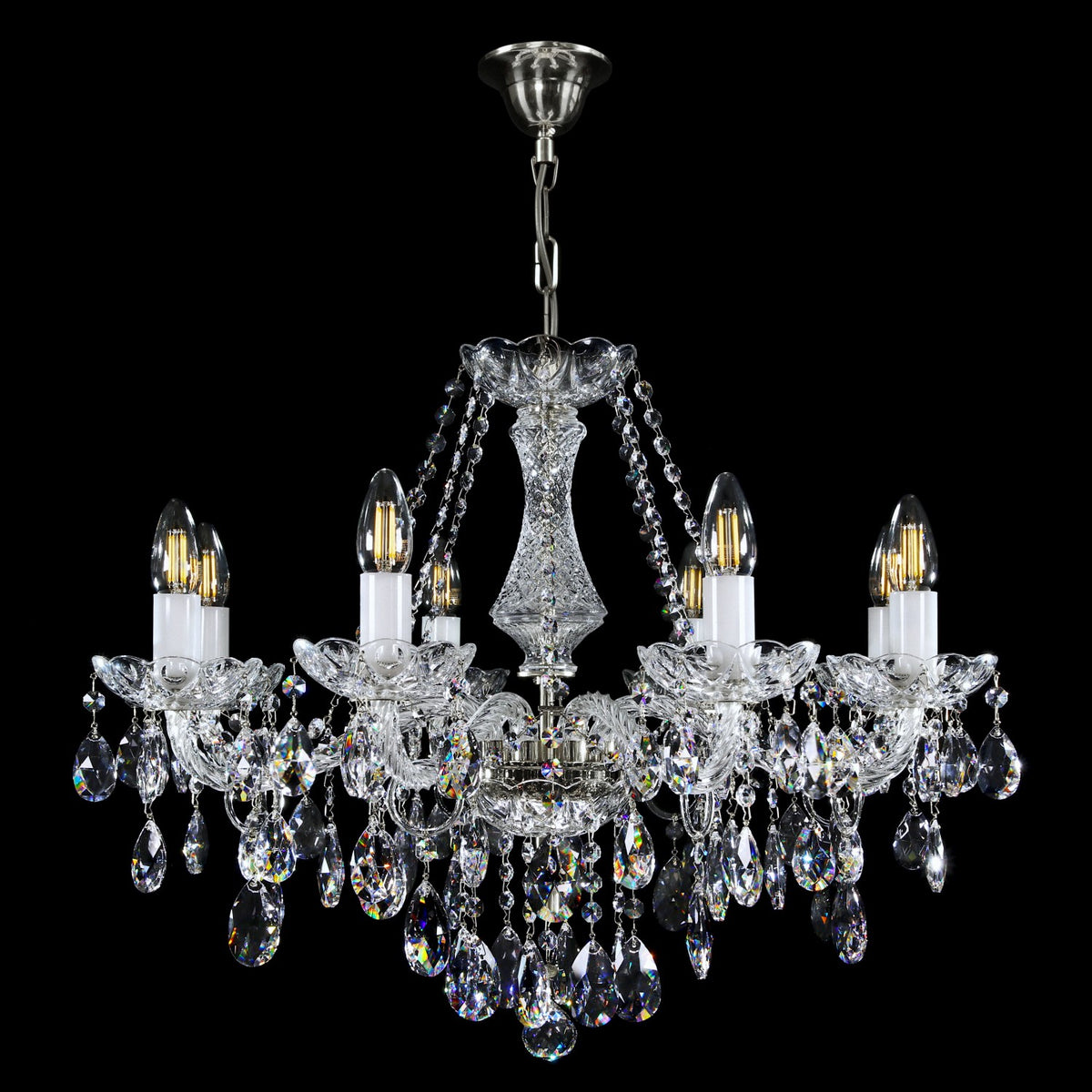 Lustre chromé suspendu, chaîne et rosace de plafond visibles sur fond noir